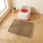 Tapis de litière beige double couche posé devant un bac à litière